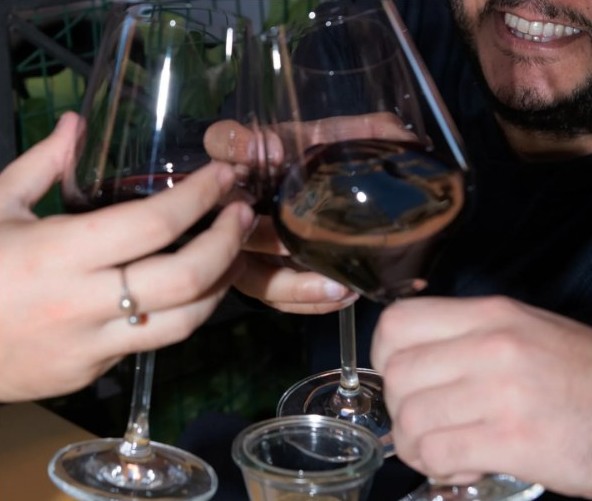 Brindisi con due calici di vino rosso